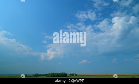 Time lapse. Ciel bleu d'été avec des nuages blancs moelleux. Des nuages blancs flottent à travers le ciel bleu. Banque D'Images