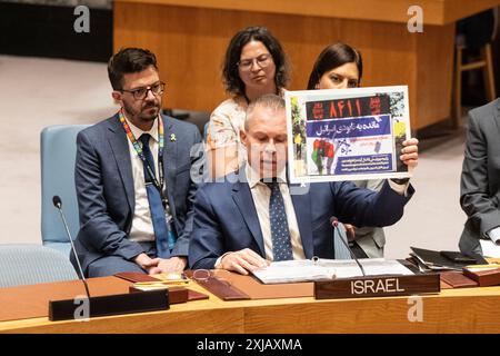 L'ambassadeur Gilad Erdan tient une photo de l'horloge de fin d'Israël installée à Téhéran, en Iran, alors qu'il s'exprimait lors d'une réunion du Conseil de sécurité sur 'la situation au moyen-Orient, y compris la question palestinienne' au siège de l'ONU à New York le 17 juillet 2024. Le calendrier semble découler des commentaires faits en 2015 par le leader suprême de l'Iran, l'ayatollah Ali Khamenei, qui a déclaré qu'il ne resterait "rien" d'Israël d'ici l'an 2040. Banque D'Images