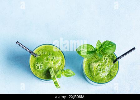 Smoothie vert détox dans des verres sur fond bleu clair, vue de dessus, espace de copie. Saine alimentation propre, concept de style de vie végétalien. Banque D'Images