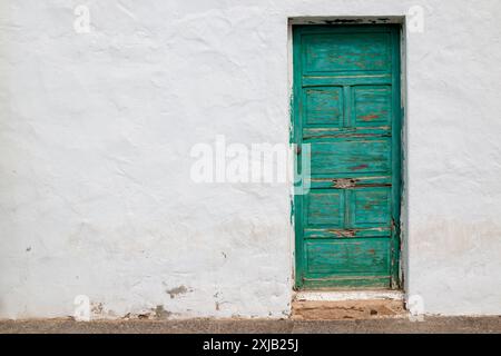 Façade blanche d'une maison. Vieille porte en bois verte. Combinaison typique de la zone. Caleta del Sebo, la Graciosa, Îles Canaries, Espagne. Banque D'Images