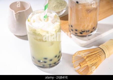 Thé à bulles boba matcha classique et vert avec perles de tapioca et crème fouettée non laitière sur le dessus du verre, boisson dessert sucrée froide d'été sur t blanc Banque D'Images