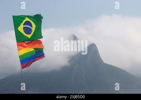 17 juillet 2024, Rio de Janeiro, Rio de Janeiro, Brésil : le drapeau national du Brésil flotte aux côtés d'un drapeau arc-en-ciel LGBT sur la plage d'Ipanema, encadré par l'emblématique Morro dois IrmÃ£os (crédit image : © Bob Karp/ZUMA Press Wire) USAGE ÉDITORIAL SEULEMENT! Non destiné à UN USAGE commercial ! Banque D'Images