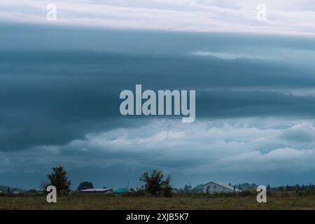 De sombres nuages de pluie pendent au-dessus des maisons de village Banque D'Images