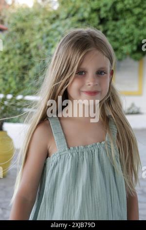 Portrait franc de mignonne fille de 7 ans Will longs cheveux blonds et chemise en lin Banque D'Images