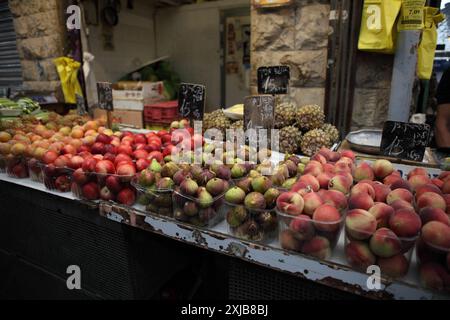 Couleurs, produits frais, pêches, figues, nectarines, prunes & ananas à vendre sur un étal de marché au marché Machane Yehuda à Jérusalem. Banque D'Images