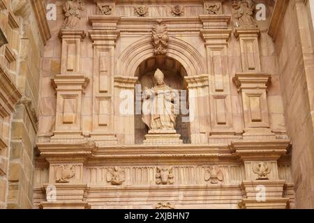 Astorga, Espagne - 3 juin 2023 : sculpture détaillée d'un évêque, vêtu de robes ornées, se dresse dans une niche de la cathédrale Santa Maria de Astorga. Banque D'Images