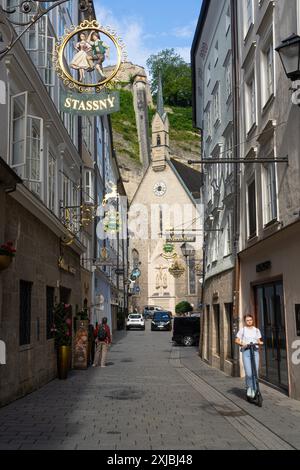 Salzbourg, Autriche. 1er juillet 2024. Vue sur les enseignes caractéristiques des magasins dans la rue Getreidegasse dans le centre-ville Banque D'Images