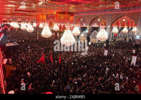 Les musulmans chiites prennent part aux rituels de deuil lors d'une procession religieuse avant la journée de l'Ashura au Sanctuaire de l'Imam Hussein. Mouharram est considéré comme un mois de deuil et de souvenir pour les musulmans chiites du monde entier, au cours duquel ils commémorent le martyre du petit-fils du prophète islamique Mohammad, Hussein ibn Ali, qui a été tué lors de la bataille de Karbala au VIIe siècle. Banque D'Images