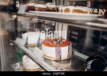 Des pâtisseries et des gâteaux variés sont magnifiquement présentés dans la vitrine d'une boulangerie Banque D'Images
