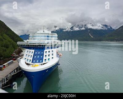 Un bateau de croisière accosté à Skagway, Alaska, avec des montagnes couvertes de nuages en arrière-plan Banque D'Images