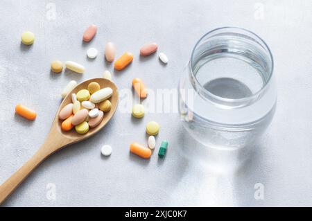 Comprimé coloré, capsules, pilules médecine en cuillère en bois, soins de santé et concept médical Banque D'Images