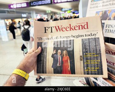 Palma, Espagne - 11 juillet 2024 : une main masculine avec une montre jaune tient un numéro de FT Weekend dans un aéroport international, mettant en vedette des manchettes sur le changement, un nouveau premier ministre, et l'ascension et la chute de Sunak. Banque D'Images