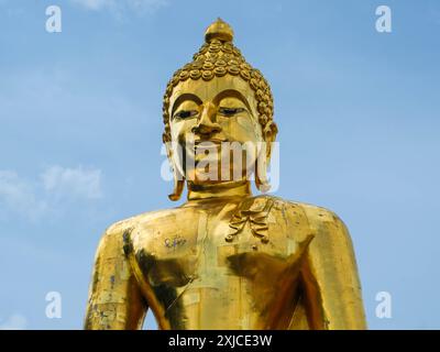 Grande statue de Bouddha dorée sur un fond de ciel lumineux - célèbre statue de sculpture Landmark dans le Temple de Thaïlande. Banque D'Images