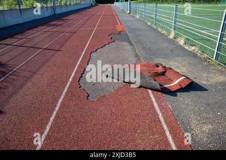 dommages sur la surface de la chenille sport en caoutchouc à l'extérieur Banque D'Images