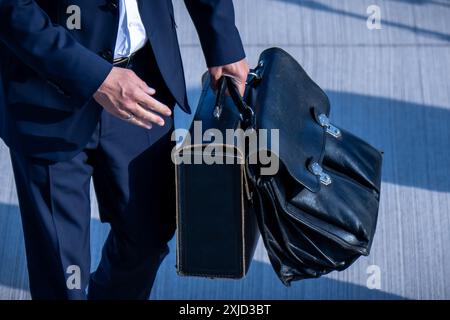 18 juillet 2024, Brandebourg, Schönefeld : le chancelier fédéral Olaf Scholz (SPD) monte à bord d'un avion avec deux mallettes pour voler vers le Royaume-Uni. Scholz participe au sommet de la Communauté politique européenne. Environ 50 chefs d'État et de gouvernement européens devraient assister au sommet du premier ministre. Photo : Michael Kappeler/dpa Banque D'Images