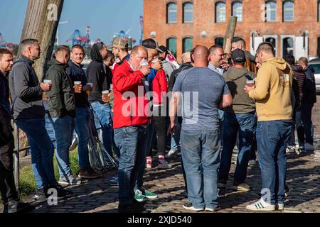 Grand groupe d'hommes buvant de la bière à l'extérieur de Fischauktionshalle le dimanche matin au marché du dimanche Fischmarkt dans le district d'Altona à Hambourg, en Allemagne Banque D'Images