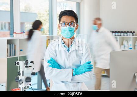Laboratoire, masque et homme en portrait avec les bras croisés, planification et investigation pour virus médical. Soins de santé, médecin asiatique et confiant avec le visage Banque D'Images