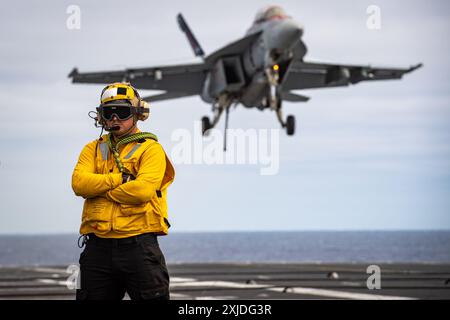 Un F/A-18F Super Hornet des « Fighting Redcocks » du Strike Fighter Squadron (VFA) 22 se prépare à effectuer un atterrissage arrêté sur le pont d’envol du th Banque D'Images