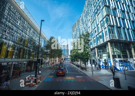 Londres, Royaume-Uni - 09 octobre 2023 : Une scène de rue à Londres, Royaume-Uni, avec une architecture moderne, une voiture rouge et des piétons marchant sur le trottoir. Banque D'Images