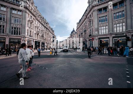 Londres, Royaume-Uni - 10 octobre 2023 : Une rue à Londres, Royaume-Uni, avec Regent Street sur le côté droit. La route est bordée de grands bâtiments, beaucoup avec des magasins A. Banque D'Images