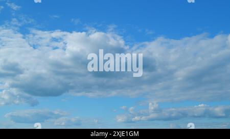 Time lapse. Formation de nuages traversant le ciel bleu. Nuages multicouches blancs et moelleux sur le ciel bleu. Banque D'Images