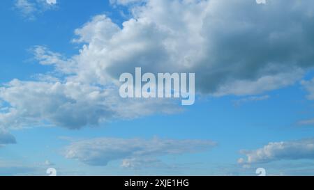 Time lapse. Des nuages blancs flottent à travers le ciel bleu. Des nuages doux et gonflés. Banque D'Images