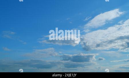 Time lapse. Formation de nuages traversant le ciel bleu. Nuages multicouches blancs et moelleux sur le ciel bleu. Banque D'Images