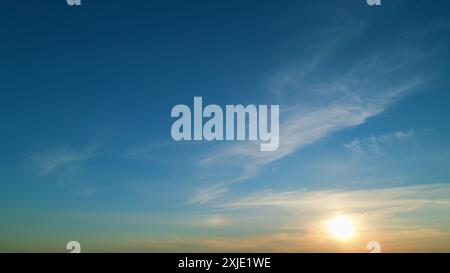 Time lapse. La compagnie aérienne d'avion à réaction vole haut dans le ciel avec des nuages laissant des traînées. Coucher de soleil chaud avec des nuages ardents et un fond de traînée d'avion. Banque D'Images