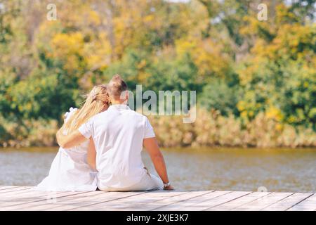 Couple s'embrassant dans le parc. Heureux nouveaux mariés près de la maison. Photo de haute qualité Banque D'Images