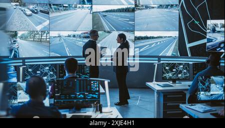 Équipe de développeurs de logiciels, ingénieurs et scientifiques de données travaillant dans une société de technologie logistique moderne. Homme et femme discutant devant un écran avec des séquences de vidéosurveillance Banque D'Images