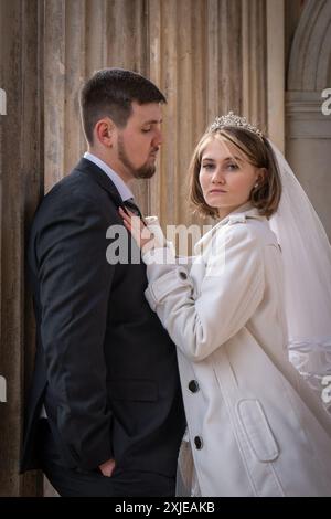 La mariée et le marié dans une belle robe longue pour une promenade parmi les colonnes hautes. famille, amour Banque D'Images