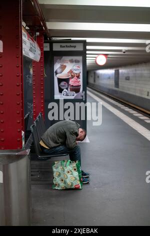 Homme sans-abri sur un bech dans une station de métro U-Bahn de Berlin, capitale de l'Allemagne, Europe Banque D'Images