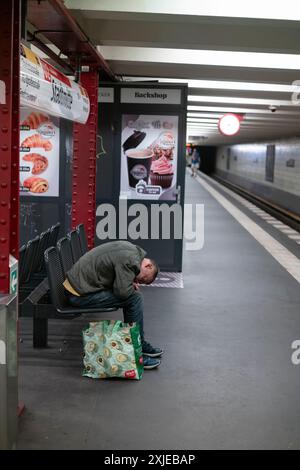 Homme sans-abri sur un bech dans une station de métro U-Bahn de Berlin, capitale de l'Allemagne, Europe Banque D'Images