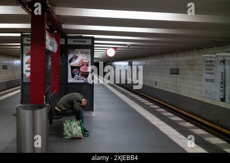 Homme sans-abri sur un bech dans une station de métro U-Bahn de Berlin, capitale de l'Allemagne, Europe Banque D'Images