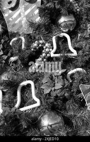 Gros plan d'un sapin de Noël joliment décoré avec des ornements colorés blancs, dorés et rouges, capturant la joie festive de la saison des fêtes. ÉTATS-UNIS Banque D'Images