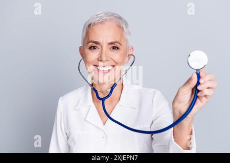 Photo de charmante femme médecin spécialiste qualifiée porter une robe blanche isolée sur fond de couleur grise Banque D'Images