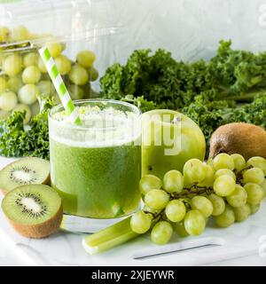 Un verre de jus vert fraîchement préparé avec des ingrédients verts sains. Banque D'Images