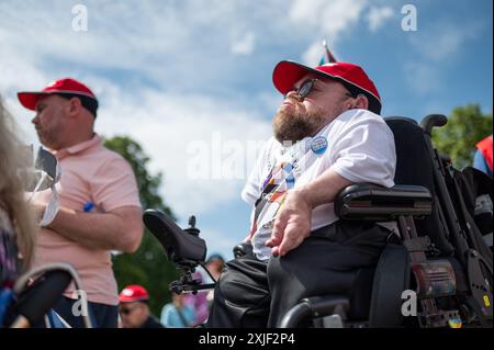 Londres, Royaume-Uni. 18 juillet 2024. Un démonstrateur écoutant le député travailliste John McDonnell alors qu’il s’adresse à la foule. DPAC (Disabled People Against Cuts) est un groupe de pression basé au Royaume-Uni qui milite pour les droits des personnes handicapées. Ils manifestent pour présenter leurs revendications au nouveau gouvernement pour une « société plus inclusive, accessible et équitable ». Crédit : David Tramontan / Alamy Live News Banque D'Images