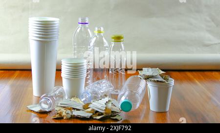 Tasse à café en papier blanc, papier usagé et boîte en carton sur une surface brune, en attente de recyclage. Encourage le recyclage des déchets, sauver la Terre et conserver Banque D'Images