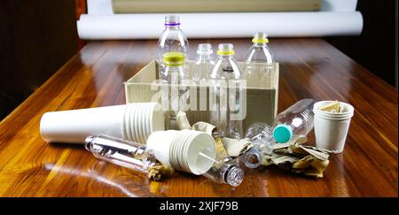 Tasse à café en papier blanc, papier usagé et boîte en carton sur une surface brune, en attente de recyclage. Encourage le recyclage des déchets, sauver la Terre et conserver Banque D'Images