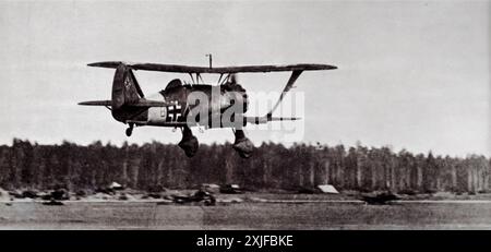 Photographie d'un avion Henschel HS 123, faisant partie de l'armée de l'air allemande (Luftwaffe), décollant pendant la seconde Guerre mondiale. Cet avion a été impliqué dans l'invasion allemande de la Pologne en 1939, une campagne militaire importante qui a marqué le début de la guerre. Le HS 123 a joué un rôle crucial en fournissant un soutien aérien rapproché aux troupes terrestres pendant l'invasion. Banque D'Images