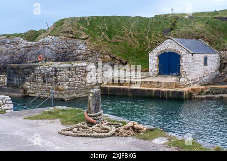 Hangar à bateaux en pierre à Ballintoy Harbour sur la Causeway Coast du nord d'Antrim en Irlande du Nord - l'un des emplacements de Game of Thrones Banque D'Images