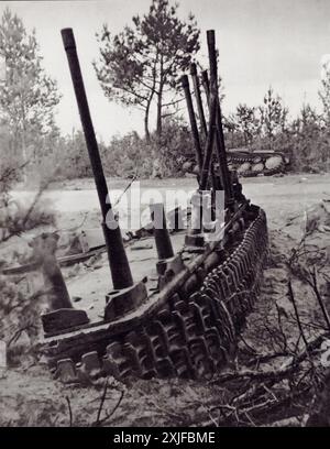 Une série de photographies montre un char soviétique complètement déchiré par un coup direct. La force de l'explosion a laissé une moitié du char avec ses essieux grippés fortement, tandis que l'autre moitié a été projetée à travers la route. La tourelle et le moteur du char ont été jetés sur 50 mètres supplémentaires dans un fossé en bordure de route. Cette image illustre l'impact dévastateur d'une frappe directe de bombe pendant la seconde Guerre mondiale. Banque D'Images