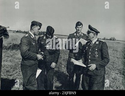 Une photographie prise en 1941 montre des membres de l'armée de l'air allemande (Luftwaffe) pendant la seconde Guerre mondiale. De droite à gauche : le chêne quitte le récipiendaire Colonel Dinord, le récipiendaire de la Croix de chevalier le premier Lieutenant Pekruhn et le récipiendaire de la Croix de chevalier le Capitaine Lau. Ces honneurs ont probablement été décernés pour leur contribution significative et leur bravoure dans le combat aérien contre les forces soviétiques pendant l'opération Barbarossa. Banque D'Images