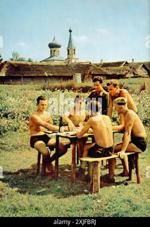 Une photographie en couleur capture des soldats allemands assis autour d'un banc, jouant à un jeu de cartes appelé skat, pendant un bref moment de temps d'arrêt. Prise en 1941 lors de l'opération Barbarossa, elle montre l'occupation allemande de la terre soviétique, alors qu'ils avancent sur le front de l'est. Banque D'Images