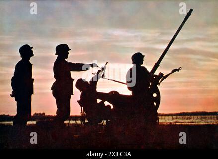 Une photographie montre des soldats apparaissant comme des silhouettes contre le soleil bas alors qu'ils manœuvrent des canons antiaériens (Flak). Prise lors de l'opération Barbarossa en 1941, cette image met en évidence les efforts de défense contre les avions soviétiques alors que les forces allemandes avançaient sur le front de l'est pendant la seconde Guerre mondiale. Banque D'Images