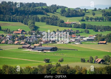 Une zone rurale avec une petite ville au milieu d'un grand champ. La ville est entourée d'arbres et de maisons Banque D'Images