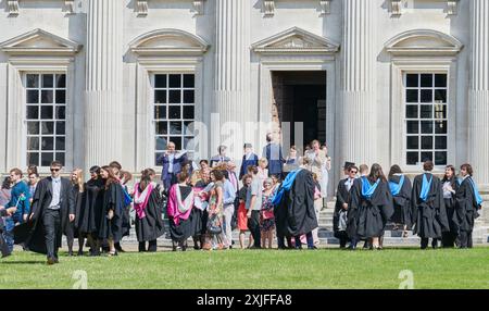 Les diplômés en tenue académique, du Trinity College, Université de Cambridge, Angleterre, célèbrent avec leur famille et leurs amis après leur cérémonie de remise des diplômes au Sénat le 18 juillet 2024. Banque D'Images