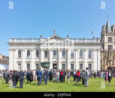 Les diplômés en tenue académique, du Trinity College, Université de Cambridge, Angleterre, célèbrent avec leur famille et leurs amis après leur cérémonie de remise des diplômes au Sénat le 18 juillet 2024. Banque D'Images