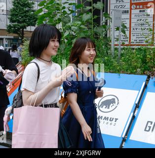 CHALEUR À TOKYO FILLES UTILISANT DES VENTILATEURS PORTABLES Banque D'Images